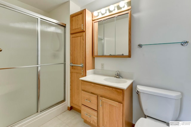 bathroom featuring an enclosed shower, vanity, tile patterned flooring, and toilet