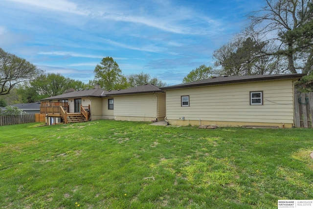 rear view of property with a lawn and a wooden deck