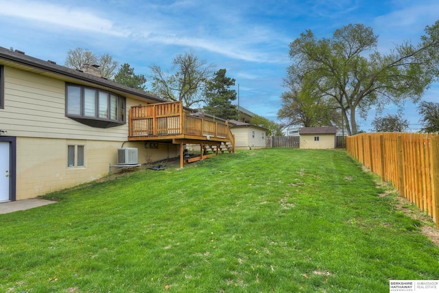 view of yard featuring a wooden deck, a shed, and central AC