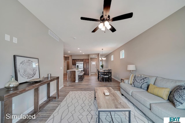 8501 Regent Ct, Lincoln, NE 68507 - living room with ceiling fan with notable chandelier and hardwood / wood-style flooring