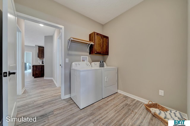 8501 Regent Ct, Lincoln, NE 68507 - laundry room with light wood-type flooring, washer and clothes dryer, a textured ceiling, and cabinets