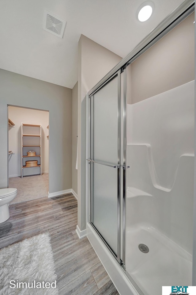 8501 Regent Ct, Lincoln, NE 68507 - bathroom featuring walk in shower, hardwood / wood-style flooring, and toilet