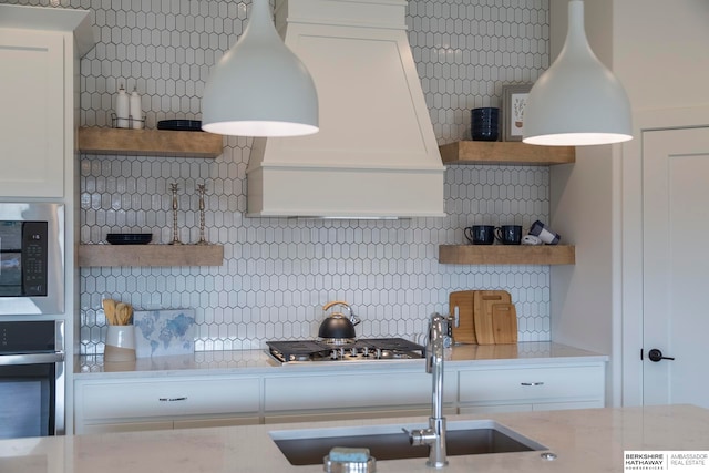 kitchen featuring appliances with stainless steel finishes, white cabinetry, and decorative backsplash