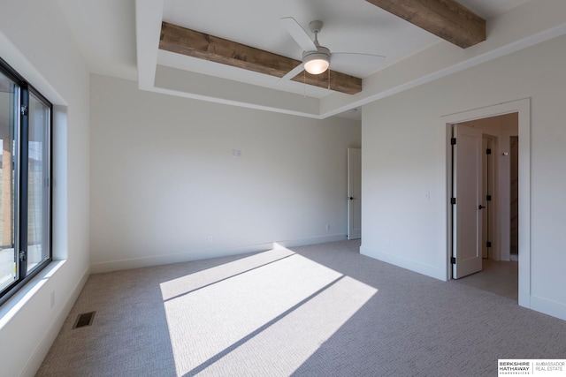 carpeted empty room with beamed ceiling and ceiling fan