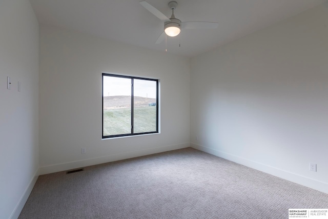 carpeted spare room with ceiling fan