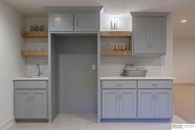 kitchen with gray cabinets, sink, and decorative backsplash