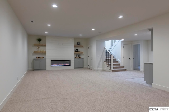 unfurnished living room with a fireplace and light colored carpet