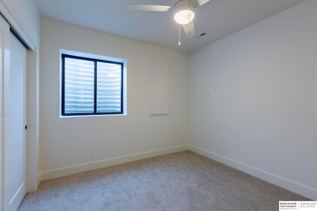 spare room with ceiling fan and light colored carpet