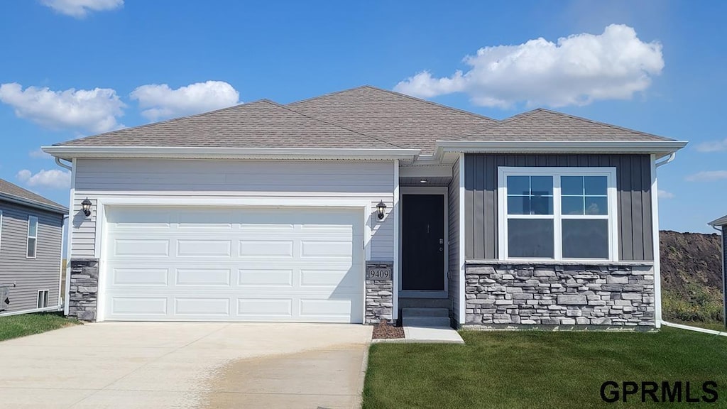 view of front of property featuring stone siding, an attached garage, concrete driveway, and roof with shingles