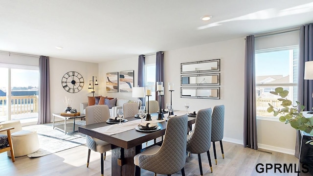 dining area with light hardwood / wood-style flooring and a wealth of natural light