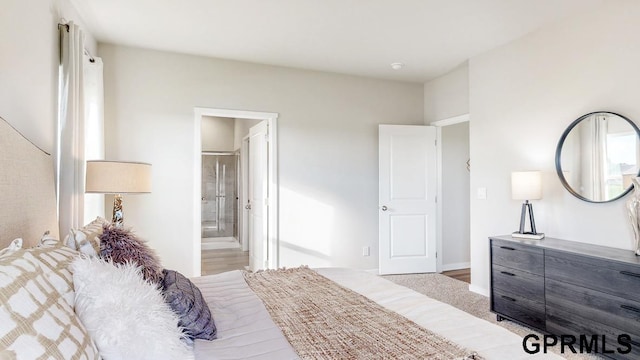 bedroom with light wood-type flooring and ensuite bath