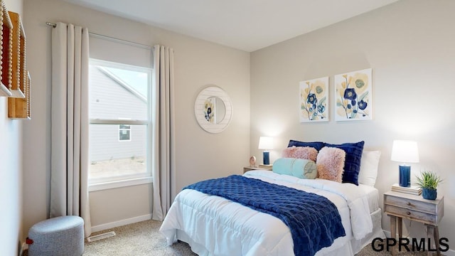 bedroom with light colored carpet and multiple windows