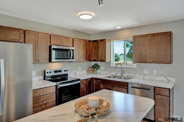 kitchen featuring light stone counters, sink, a textured ceiling, and appliances with stainless steel finishes