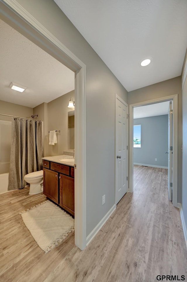 full bathroom featuring vanity, hardwood / wood-style flooring, toilet, and shower / tub combo with curtain