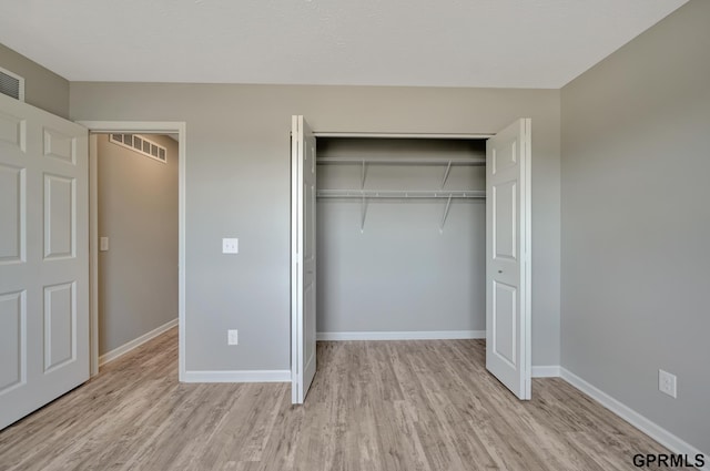 unfurnished bedroom with light hardwood / wood-style flooring and a closet