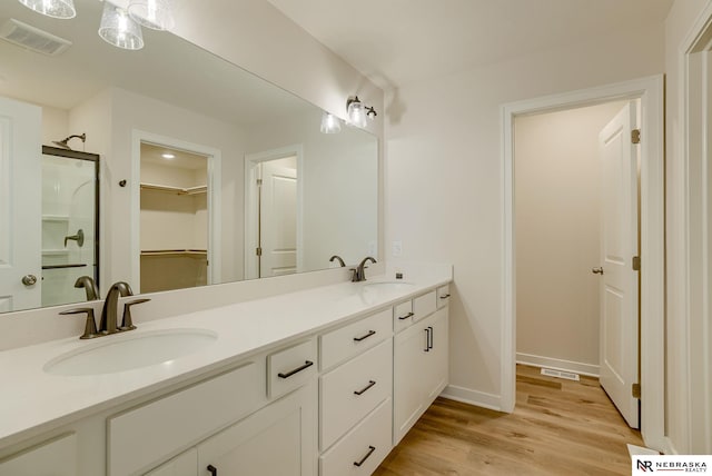 bathroom featuring vanity, hardwood / wood-style floors, and walk in shower