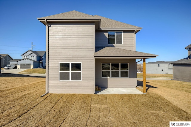 back of property with a lawn and a patio area