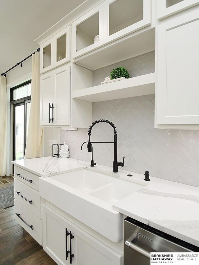 kitchen featuring decorative backsplash, white cabinets, and light stone counters