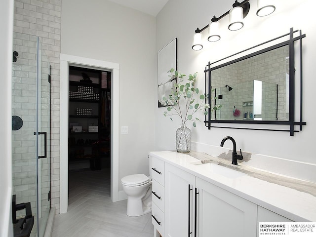 bathroom with walk in shower, vanity, parquet flooring, and toilet