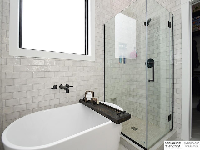 bathroom featuring separate shower and tub