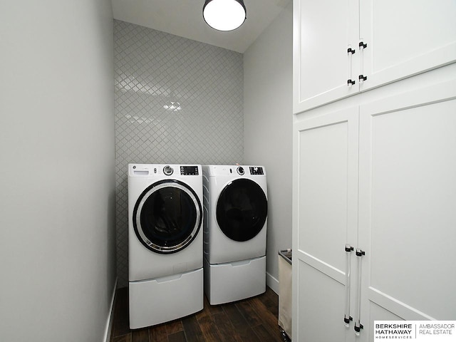 clothes washing area featuring cabinets, dark hardwood / wood-style flooring, and washer and dryer