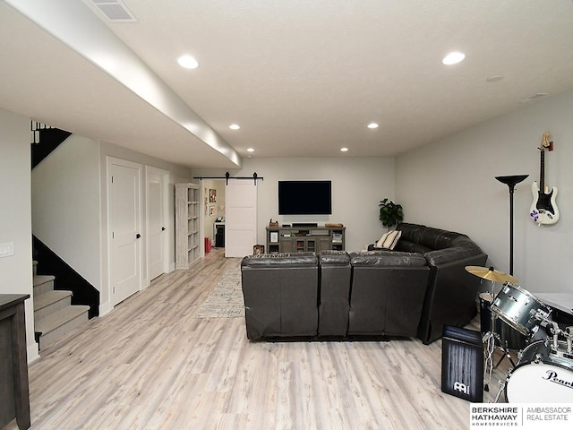 living room with light hardwood / wood-style flooring and a barn door