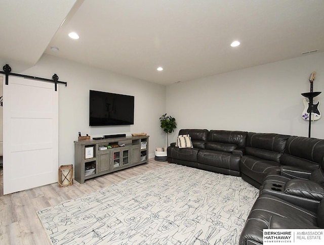 living room featuring light hardwood / wood-style flooring and a barn door