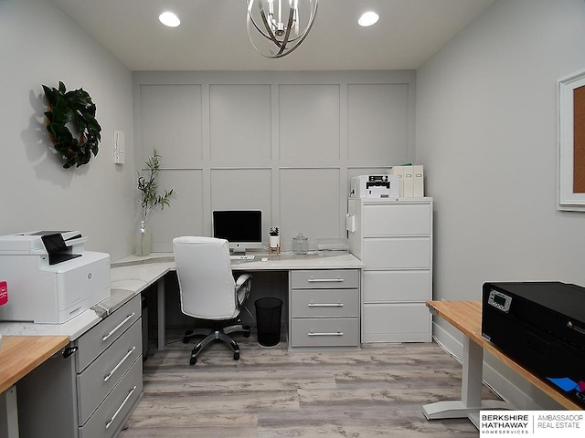 office area featuring light hardwood / wood-style flooring, built in desk, and a chandelier