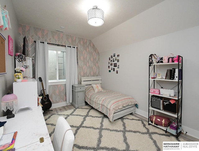 bedroom with light wood-type flooring and lofted ceiling