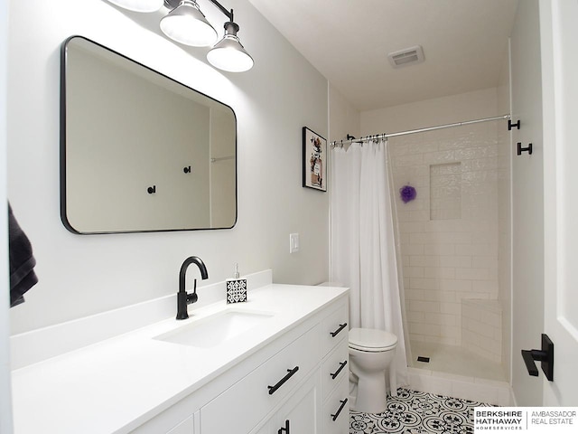 bathroom featuring walk in shower, vanity, toilet, and tile patterned floors