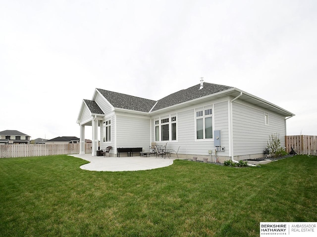 back of property with a lawn and a patio area