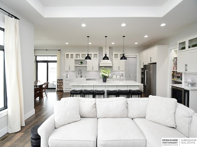 living room featuring wine cooler, sink, and dark hardwood / wood-style flooring