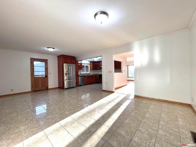 unfurnished living room featuring a wealth of natural light and crown molding