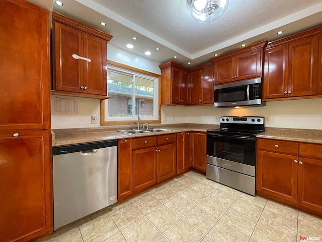 kitchen featuring light tile patterned floors, a textured ceiling, stainless steel appliances, and sink