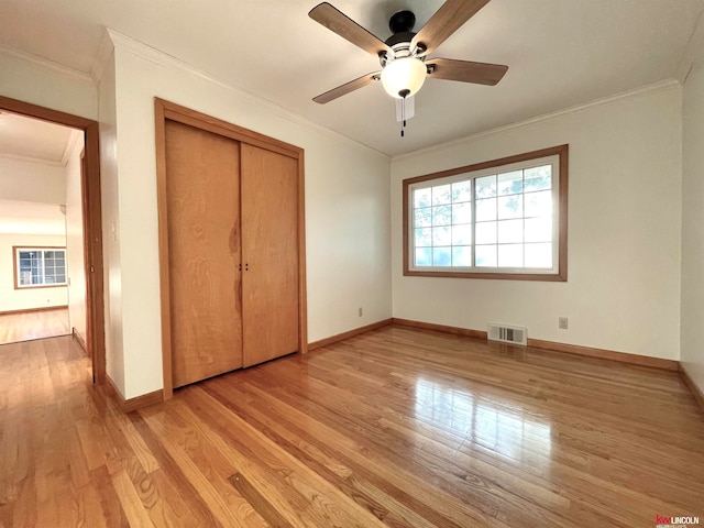 unfurnished bedroom featuring ornamental molding, ceiling fan, light hardwood / wood-style flooring, and a closet