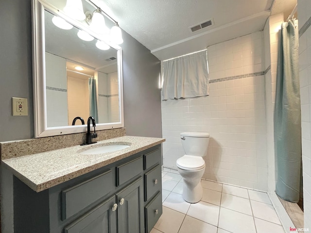 bathroom with vanity, a textured ceiling, walk in shower, toilet, and tile patterned floors