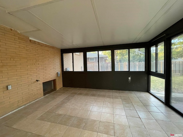 unfurnished sunroom featuring a fireplace