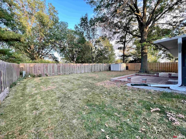 view of yard featuring a storage unit and a wooden deck