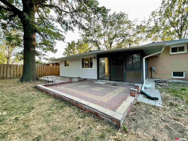 back of property with a lawn and a patio