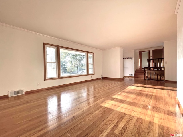 unfurnished living room featuring ornamental molding and hardwood / wood-style floors