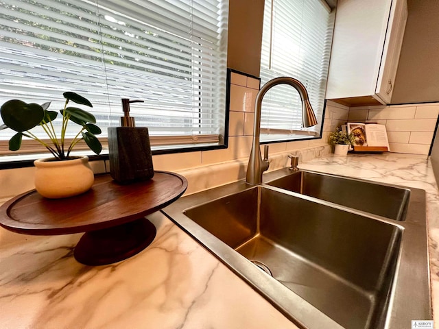 interior details featuring sink and decorative backsplash