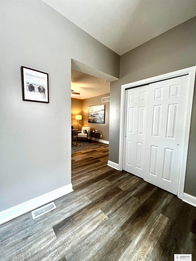 unfurnished bedroom with dark hardwood / wood-style floors and a closet