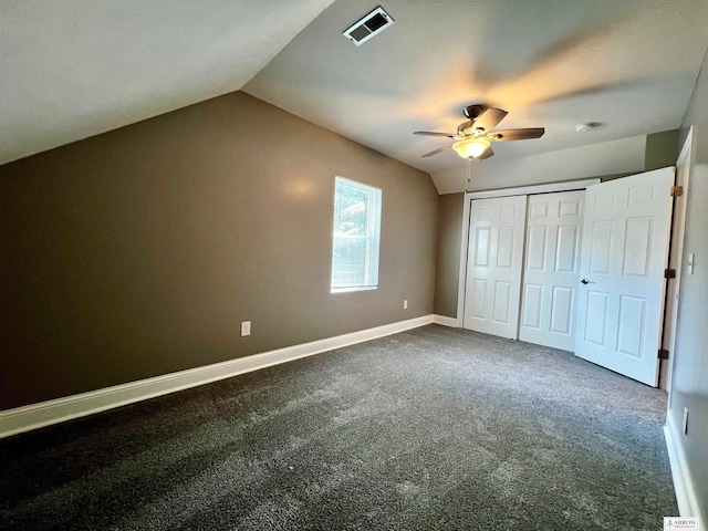 unfurnished bedroom featuring ceiling fan, a closet, vaulted ceiling, and carpet