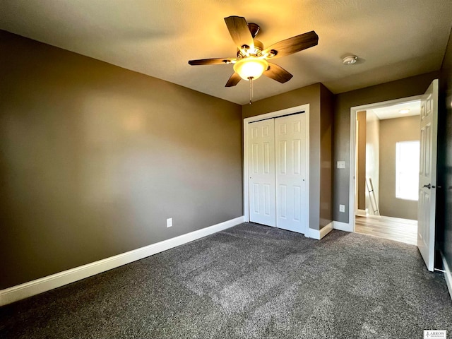 unfurnished bedroom featuring dark carpet, ceiling fan, and a closet