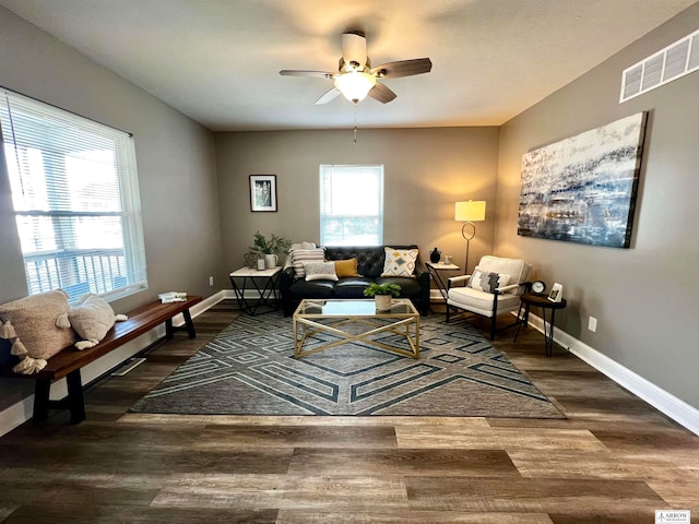 living room featuring ceiling fan and dark hardwood / wood-style flooring