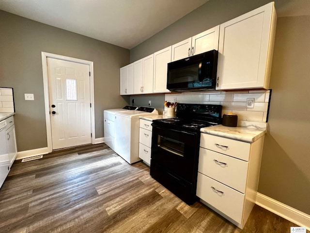 kitchen with white cabinets, independent washer and dryer, dark hardwood / wood-style flooring, and black appliances