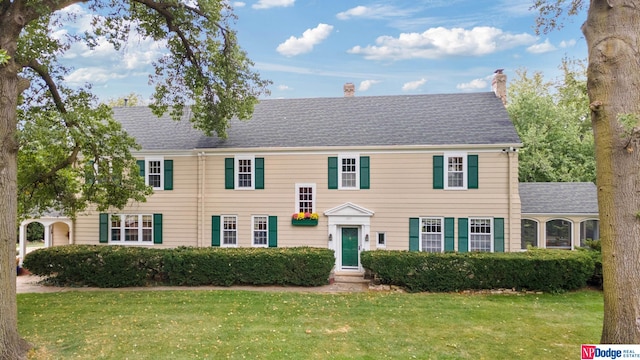 colonial-style house with a front lawn