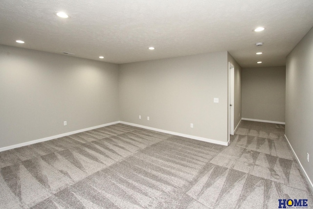 empty room featuring carpet and a textured ceiling