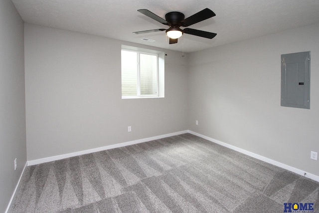 empty room featuring carpet flooring, electric panel, and ceiling fan