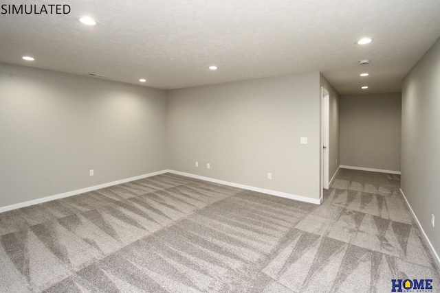 spare room featuring carpet and a textured ceiling